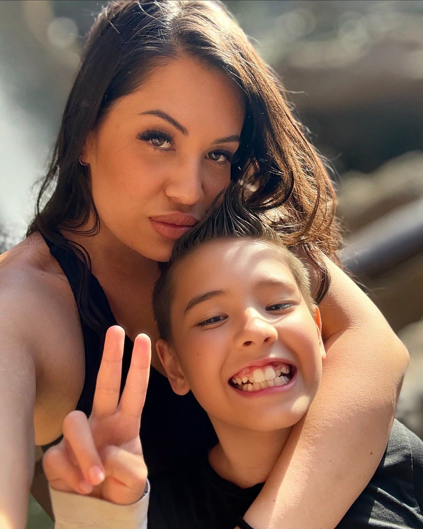 Lara and her son Kobe, cheek to cheek, smiling